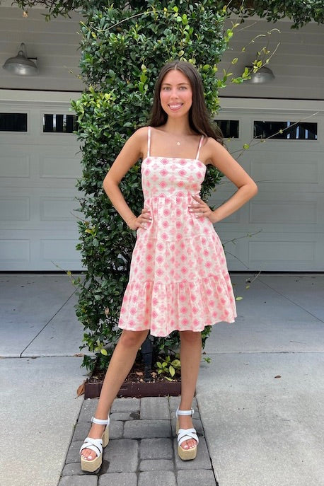 Pretty bright pink embroidered dress with adjustable straps, tiered skirt, elastic back, and tie back detail. Perfect cool cotton dress for a summer day.